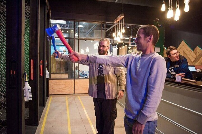 A person holding a blue and red object, pointing. 1