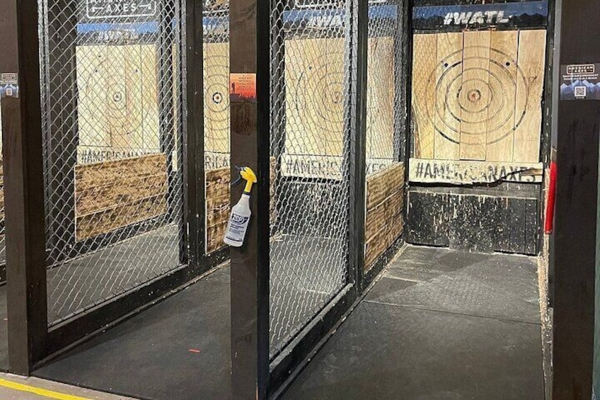A fenced area with a target on the wall and a spray bottle hanging on the fence. 4