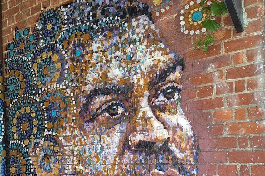A mosaic portrait on a brick wall. 3