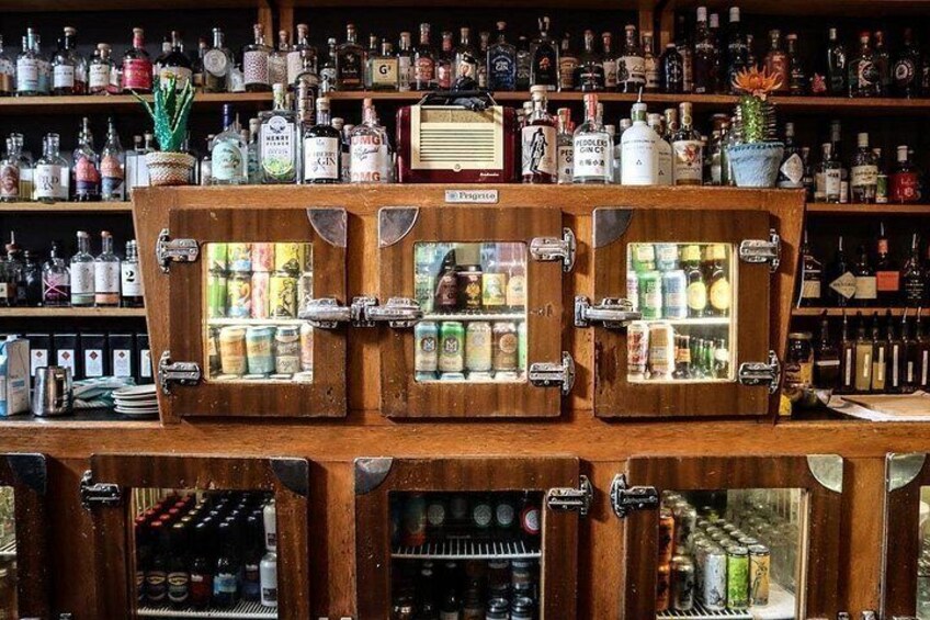 A bar with wooden cabinets containing bottles. 2