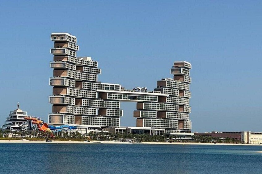 A modern architectural structure with multiple levels and balconies, situated by a body of water. 3
