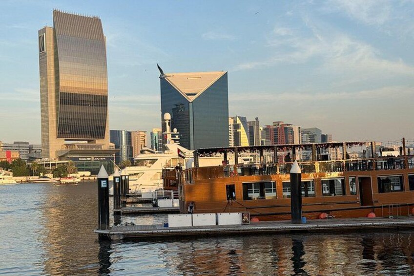 A modern city skyline with distinctive skyscrapers, a river, and a boat docked at the pier. 2
