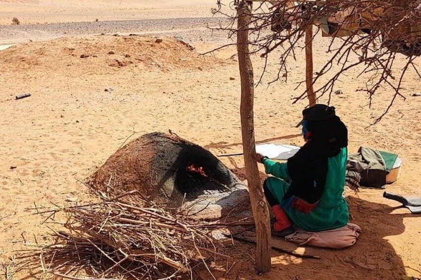 A person sitting under a tree in a desert landscape. 4