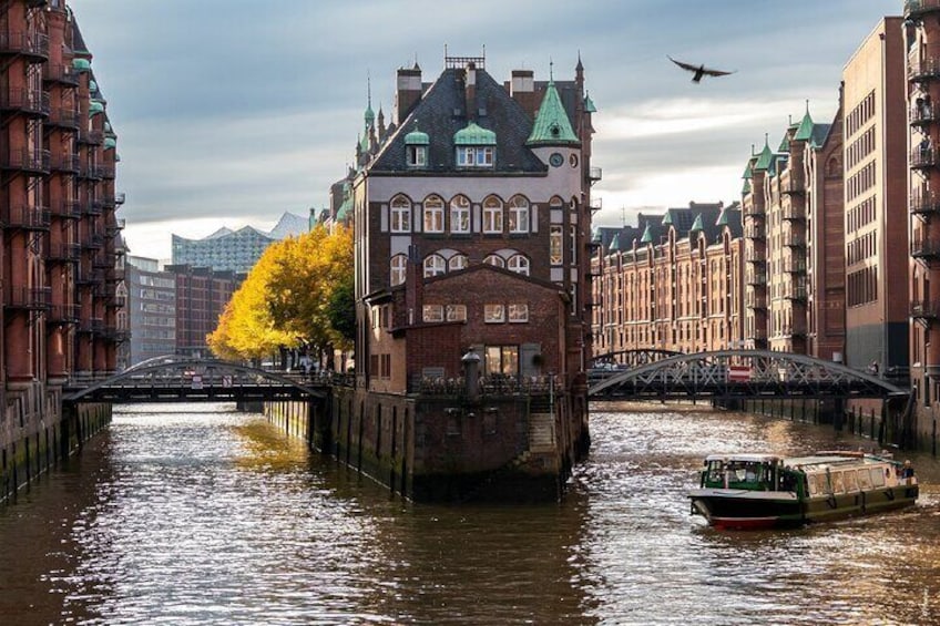 Un canal con un bote, un puente y edificios con tejados verdes. 4