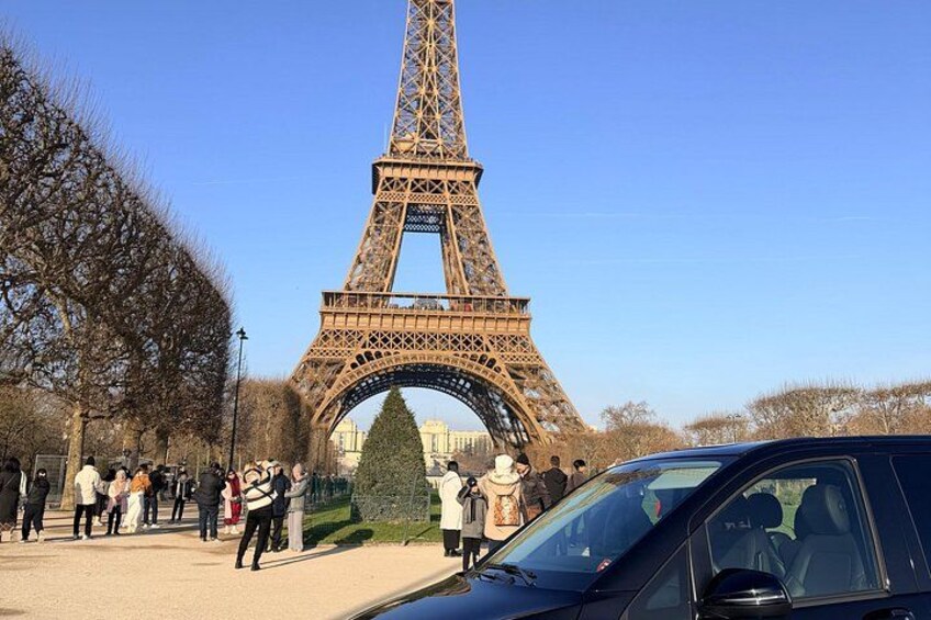 La Torre Eiffel, una gran torre de celosía de hierro, con gente caminando alrededor. 1