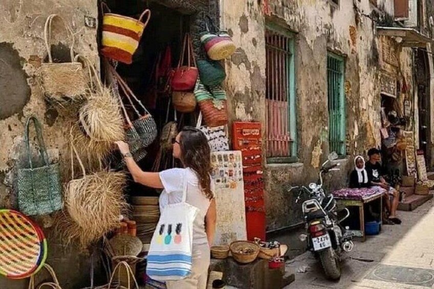 Un venditore ambulante offre borse e una moto parcheggiata sul lato della strada. 5