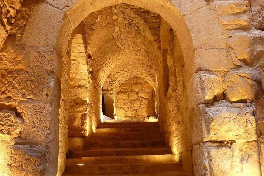 Una escalera de piedra con un arco que conduce a un nivel superior. 3
