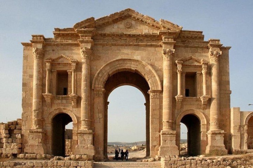 Un antiguo arco de piedra con columnas, probablemente parte de un sitio histórico. 1