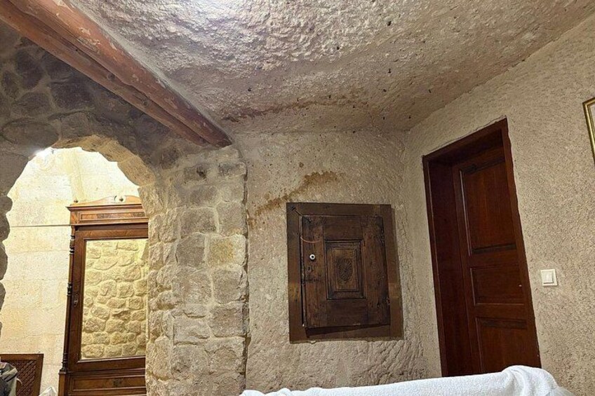 A stone-walled room with a wooden door and a window. 2
