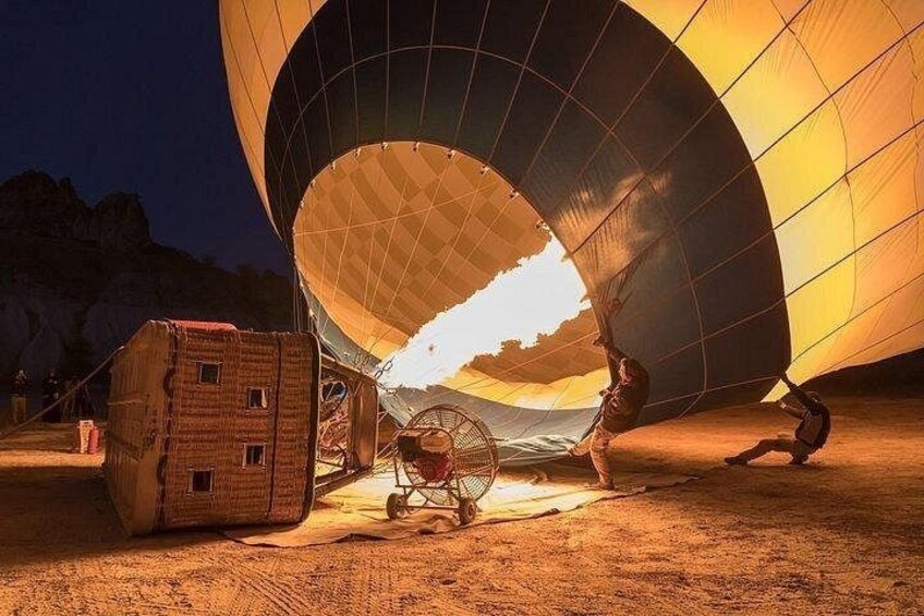 A large, illuminated structure with a dome-like roof, a small building, and a cart. 4