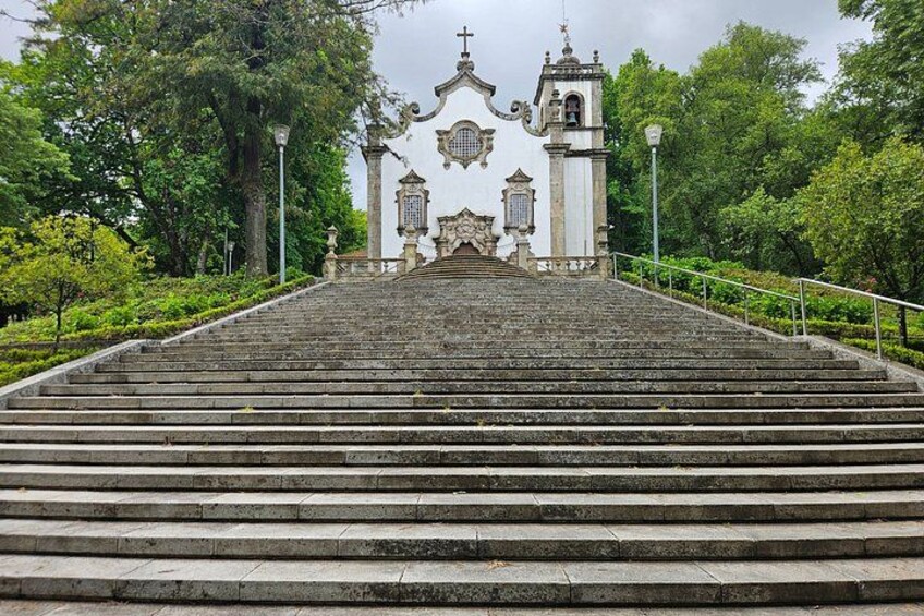 A stone staircase leading to a white building with ornate details and a bell tower. 5