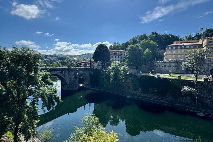 A river, a stone bridge, and buildings along the riverbank. 2