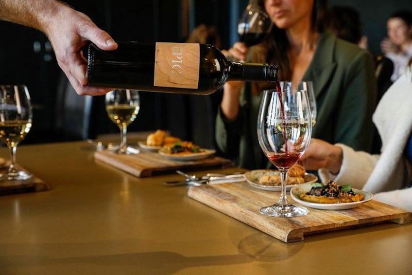 A person pouring wine into a glass. 1
