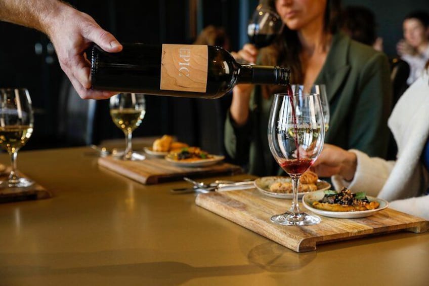A person pouring wine into a glass. 1