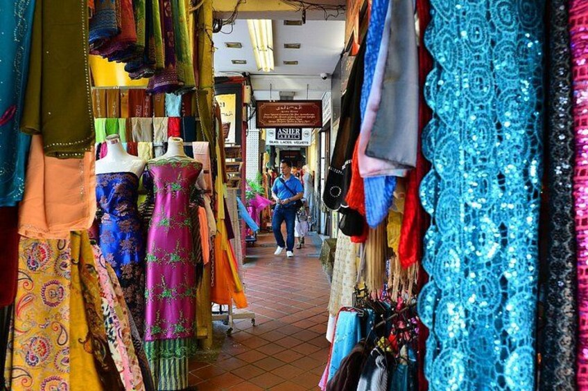 A market with colorful fabrics and mannequins displaying dresses. 2