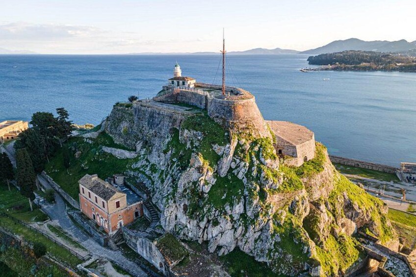 A coastal fortification with a lighthouse, steep cliffs, and a small building. 5