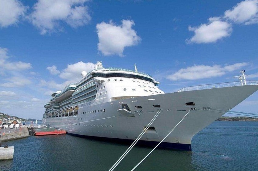 A large cruise ship docked at a port with a clear sky and calm water. 4