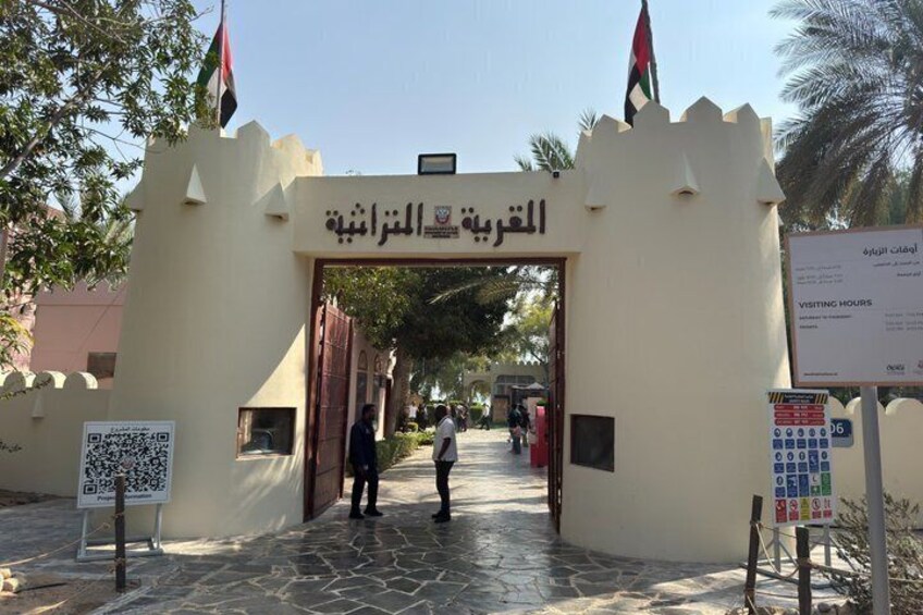 A gate with Arabic text, a flag, and a QR code. 2