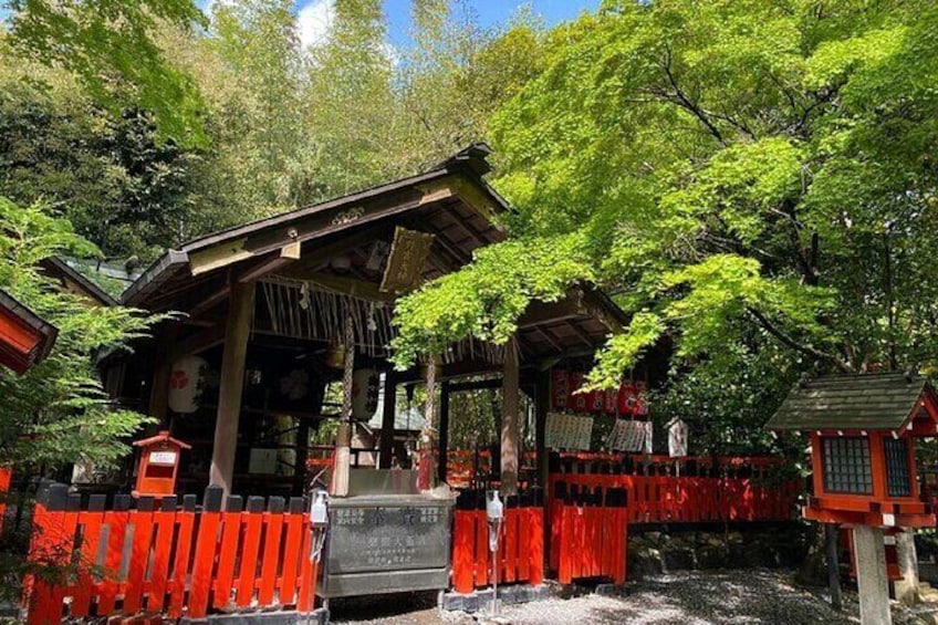 Un sanctuaire japonais traditionnel, entouré de clôtures rouges et d’une végétation luxuriante. 2