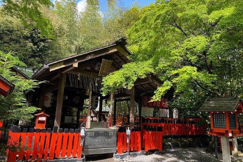 A traditional Japanese shrine surrounded by red torii gates, with a wooden structure and a stone lantern in the foreground. 2