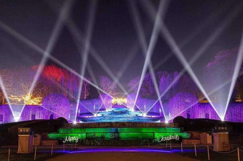 A nighttime outdoor scene with illuminated trees and a fountain. 2