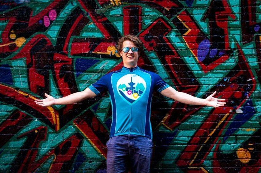 A person standing in front of a colorful graffiti wall. 3