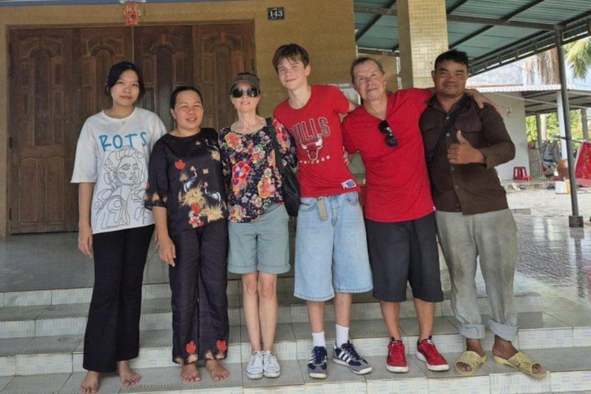 A group of people standing on steps in front of a building with a large door. 2