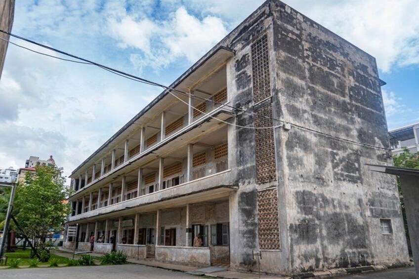 A multi-story building with a balcony, a patterned wall, and a clear sky. 5
