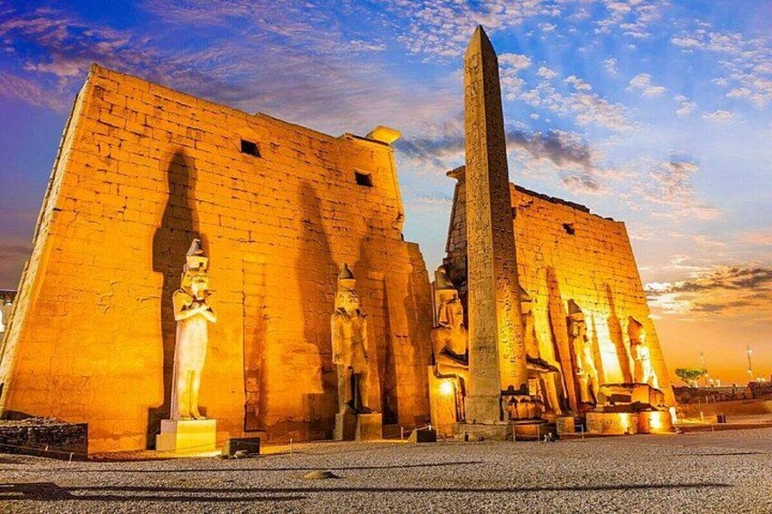 Ett forntida egyptiskt tempel med en stor obelisk och statyer. 1