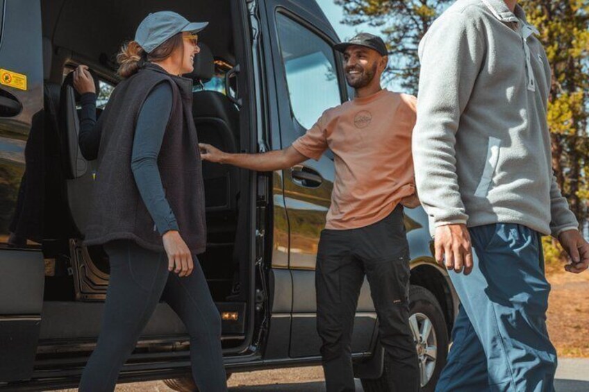 A group of people exiting a black vehicle. 3