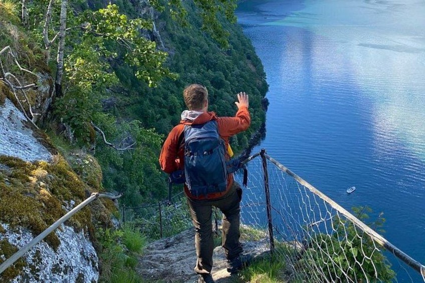 Una persona caminando por un sendero de montaña con vistas a un lago. 5