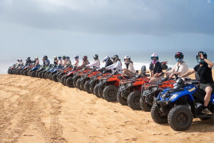 Une rangée de quads sur une plage de sable, avec l’océan en arrière-plan. 1