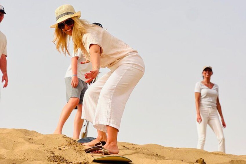 A person riding a dune buggy on a sandy dune. 1