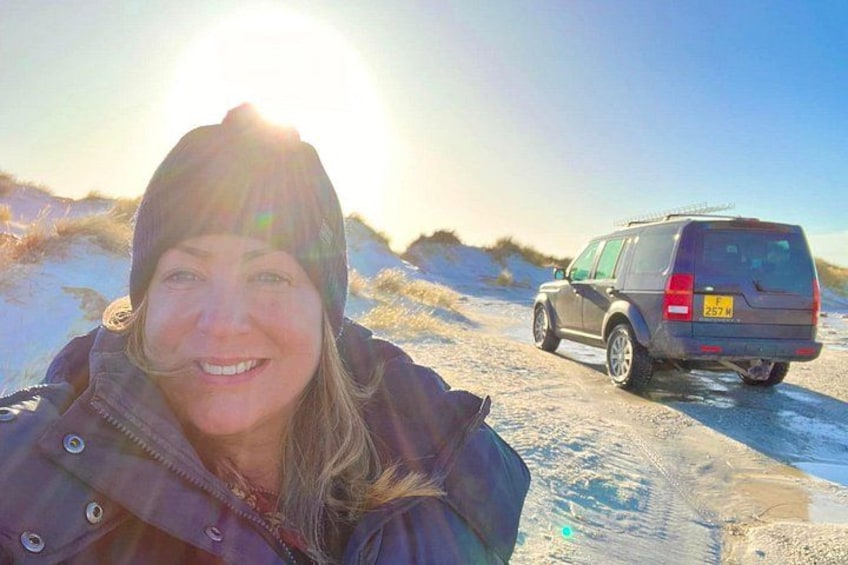 A person in winter clothing, a vehicle, and a snowy landscape. 2