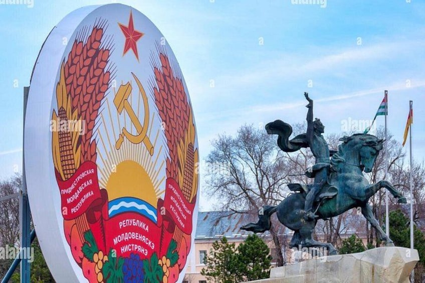 A large emblem with a hammer and sickle, a statue of a rider on a horse, and a flag. 3