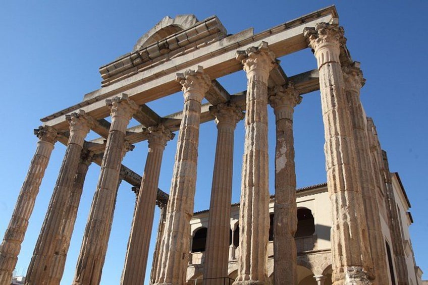Ancient Greek columns, a clear sky, and a partially intact temple structure. 4