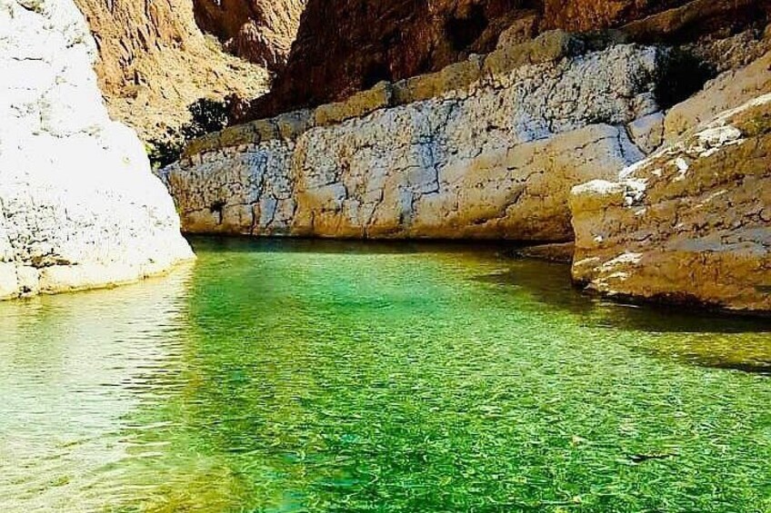 A clear water body surrounded by rocky cliffs. 1