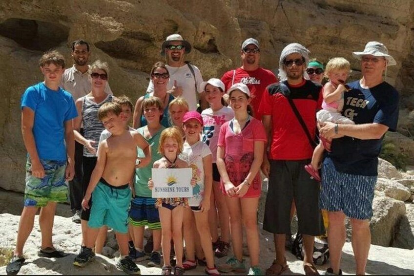 A group of people posing in front of a rocky landscape. 4