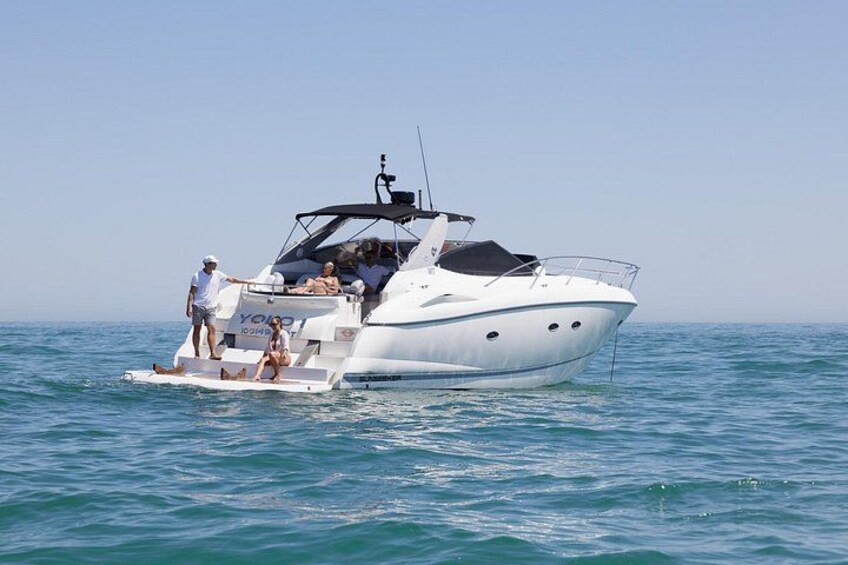 Un yacht blanc, doté d’une cabine et d’un moteur à l’arrière, navigue sur des eaux bleues et calmes. 1