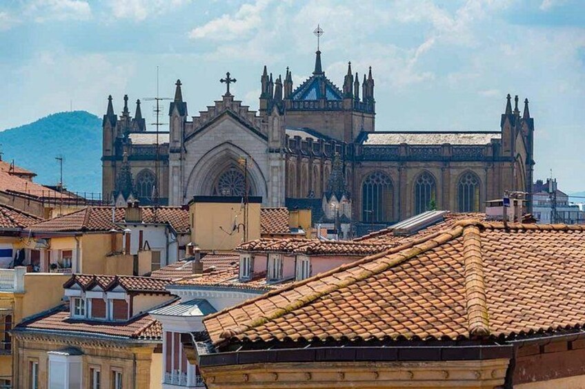 En historisk katedral med detaljeret arkitektur, et tag med fliser og et bjerglandskab i baggrunden. 3