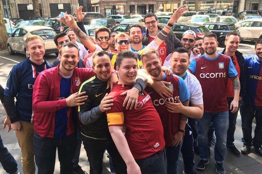 A group of people in sports jerseys posing for a photo on a city street. 4