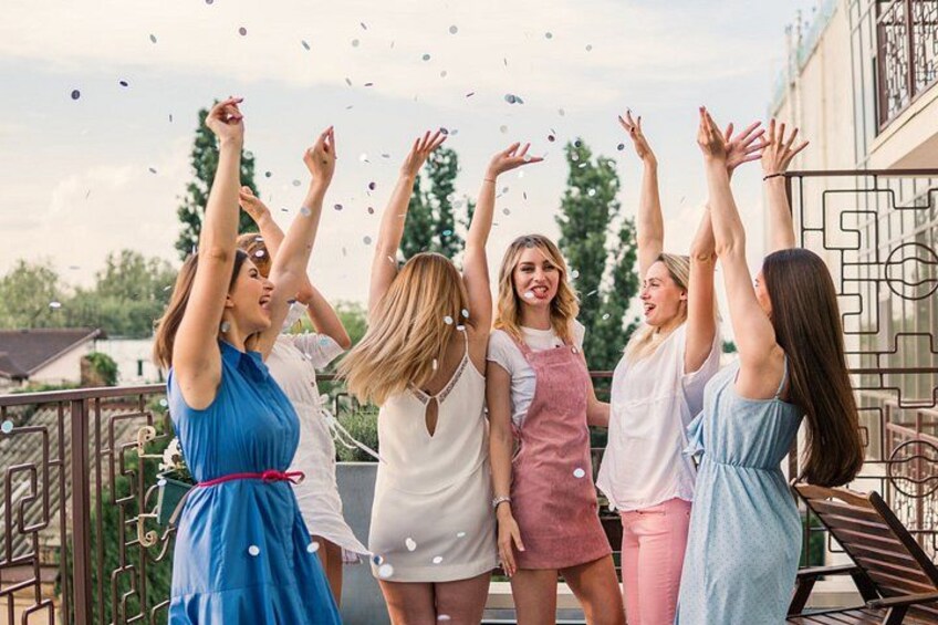 A group of people on a balcony, some with raised arms, possibly celebrating. 2