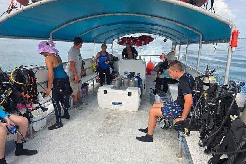 A group of people on a boat with scuba diving equipment. 2