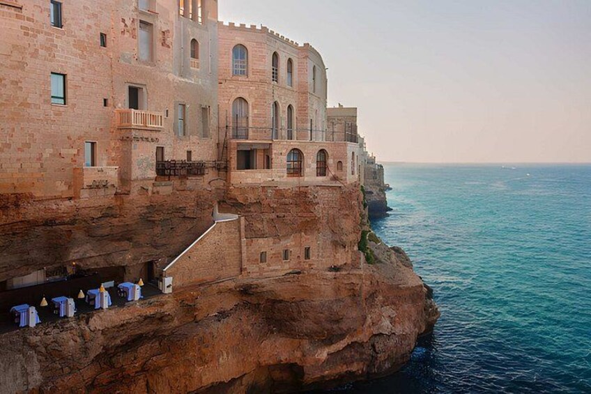 Un bâtiment historique doté d’arcs en plein cintre et d’un balcon, situé sur une falaise surplombant la mer. 5