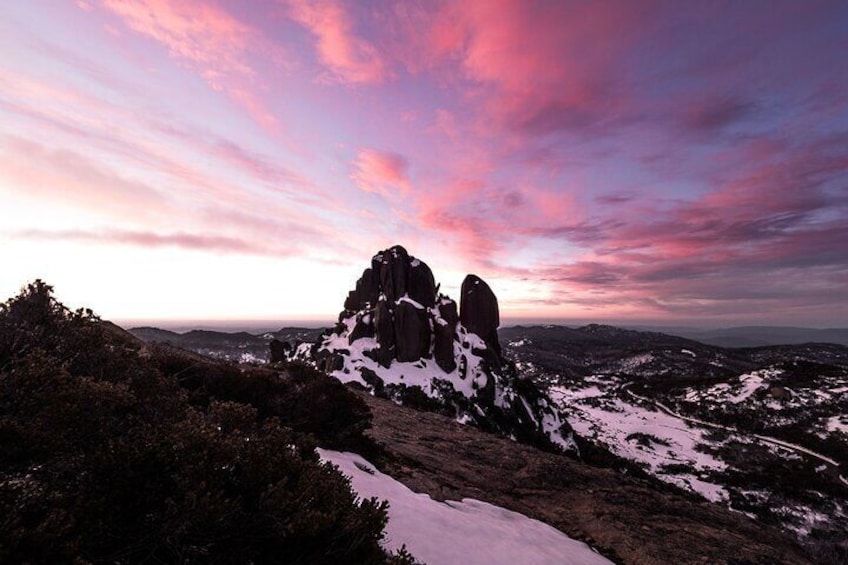 A mountainous landscape with snow-covered peaks and a dramatic sunset sky. 3