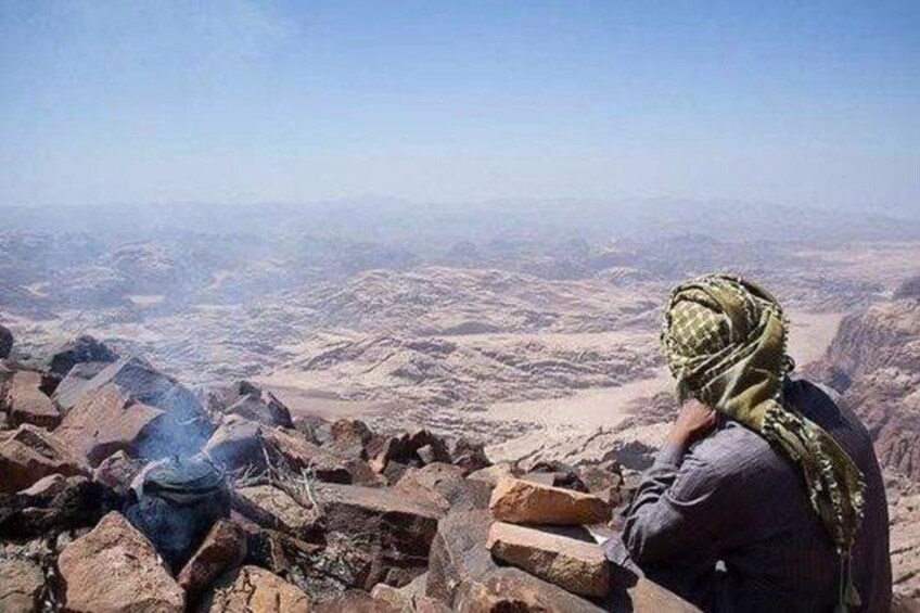A person sitting on rocks overlooking a vast desert landscape. 2