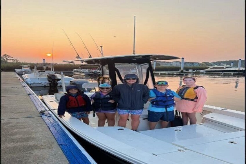 Un grupo de personas en un barco amarrado en una marina durante el atardecer. 2