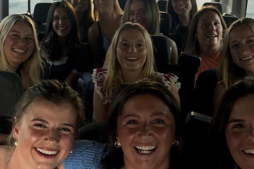 A group of people seated in a vehicle. 5