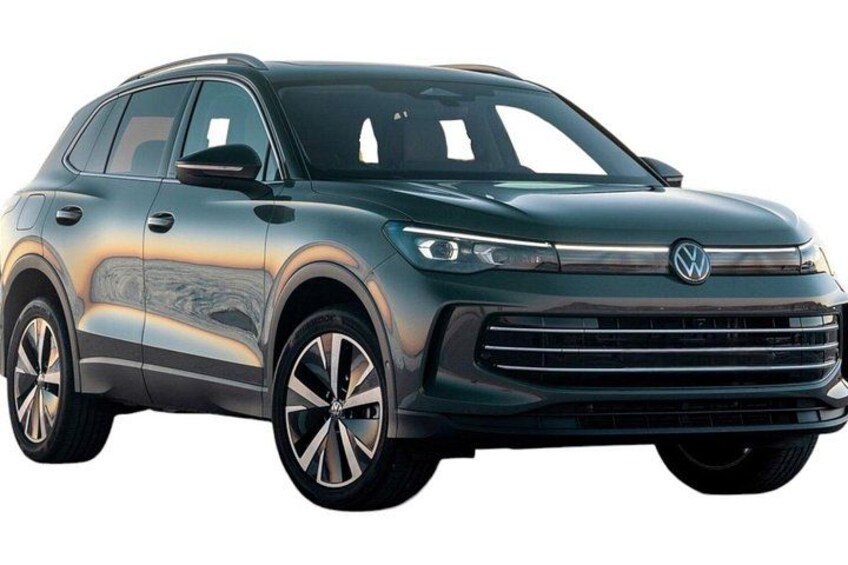 A dark-colored SUV with a distinctive grille and logo, large alloy wheels, and a sleek design. 4