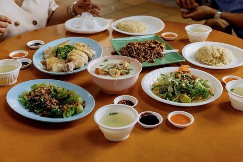 A table with various dishes, including rice, vegetables, and meat, accompanied by small bowls of sauces. 2